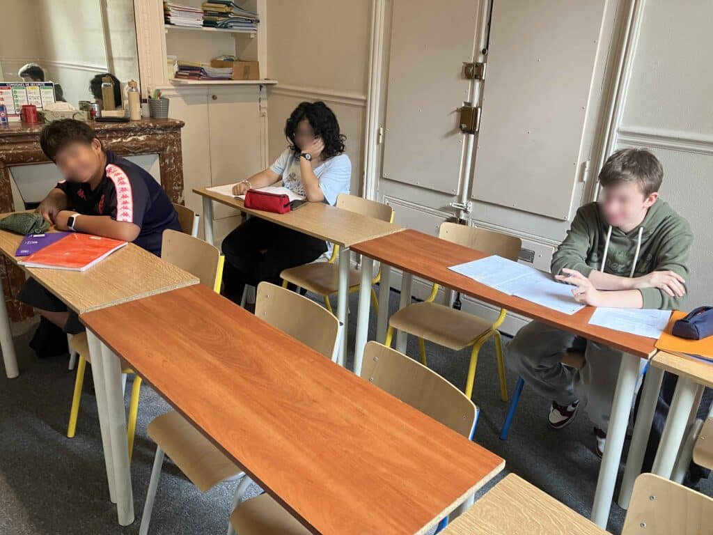 3 lycéens en cours de physique-chimie à Paris
